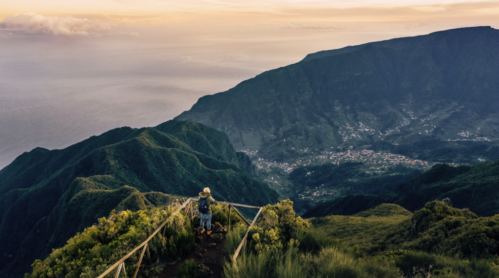 A person standing on a viewpoint in Pico Ruivo do Paul, Madeira during sunrise.